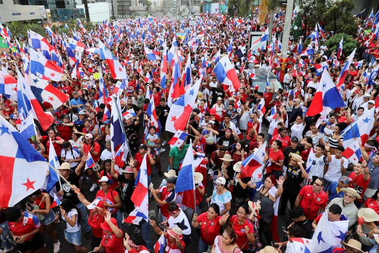 A crowd waves Panamanian flags.