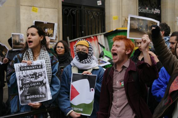 Demonstrators hold posters reading "dismantle colonial borders" as students occupy a building of the Institute of Political Studies (Sciences Po Paris) in support of Palestinians, in Paris on April 26, 2024.