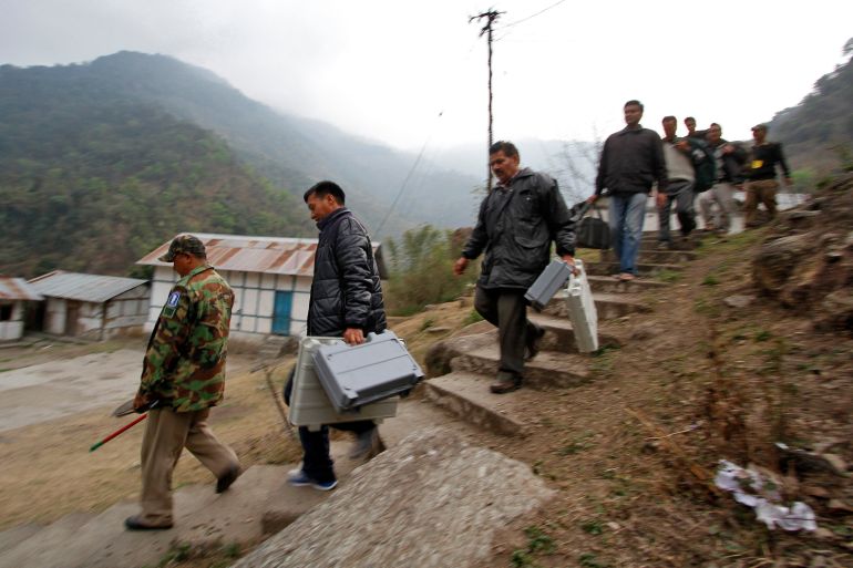 Electoral staff carry electronic voting machines (EVM) to a polling centre at Kaspi village, in the northeastern Indian state of Arunachal Pradesh April 8, 2014.
