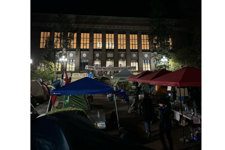 A photo of a building on University of Michigan's campus and tents pitched in front of it