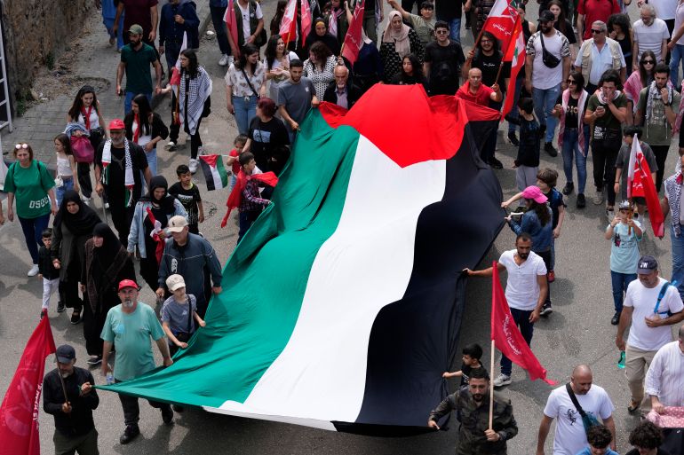 Supporters of the Lebanese Communist party, wave a giant Palestinian flag