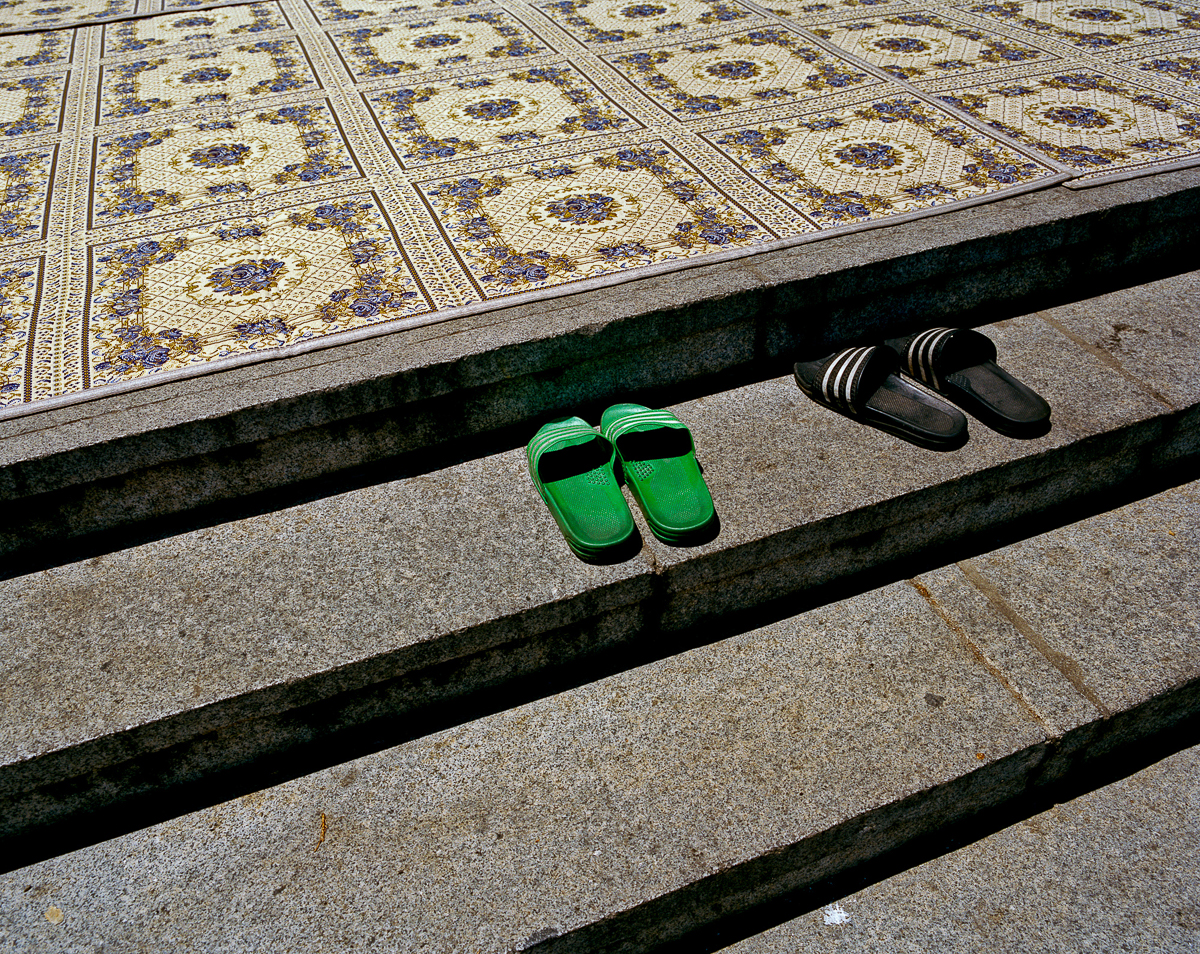 Sandals left at the footstep of the entrance to the main prayer hall. The mosque, which gathers around 800 worshippers every Friday, was built in 1974 and opened its doors in 1976. [Radu Diaconu/Al Jazeera]