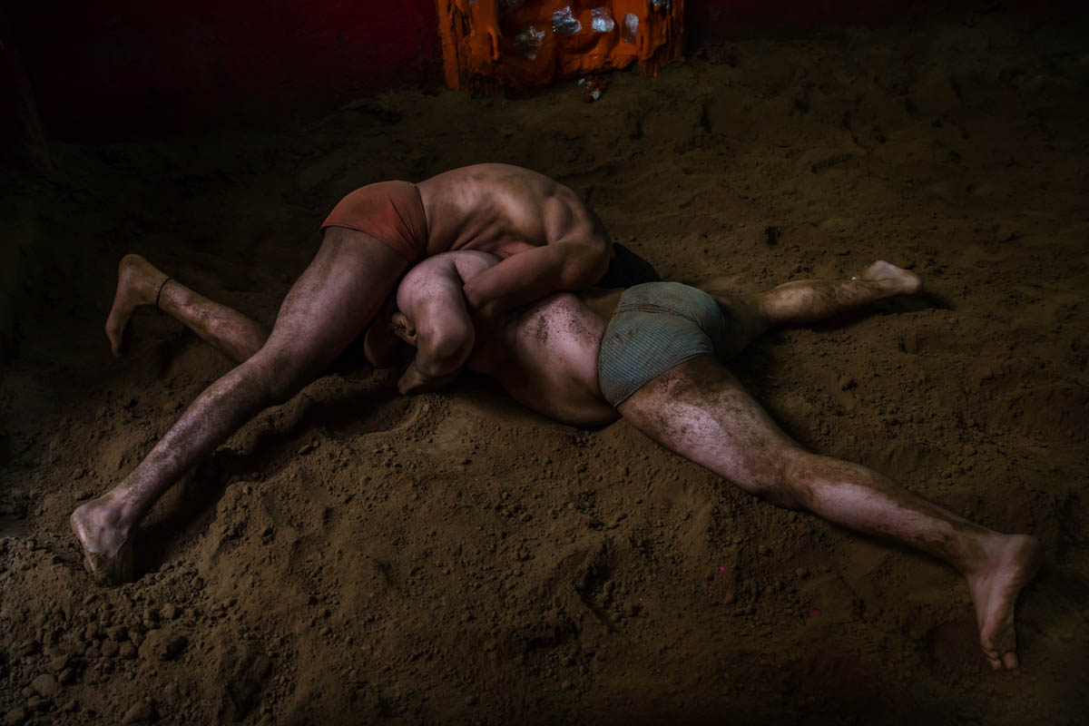 Indian kushti wrestlers fight in the ring, during their daily training at an akhada, a kind of wrestling hostel at Sabzi Mandi, in New Delhi. Kushti wrestling faces the threat of being left behind. But for many poor families, the ancient sport provides a glimmer of hope. [Dar Yasin/AP Photo]