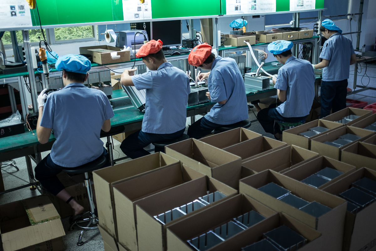 Employees work on an assembly line of AntMiner S9 mining machines at Bitmain's manufacturing base, Shenzhen, China. [EPA/Liu Xingzhe/CHINAFILE]