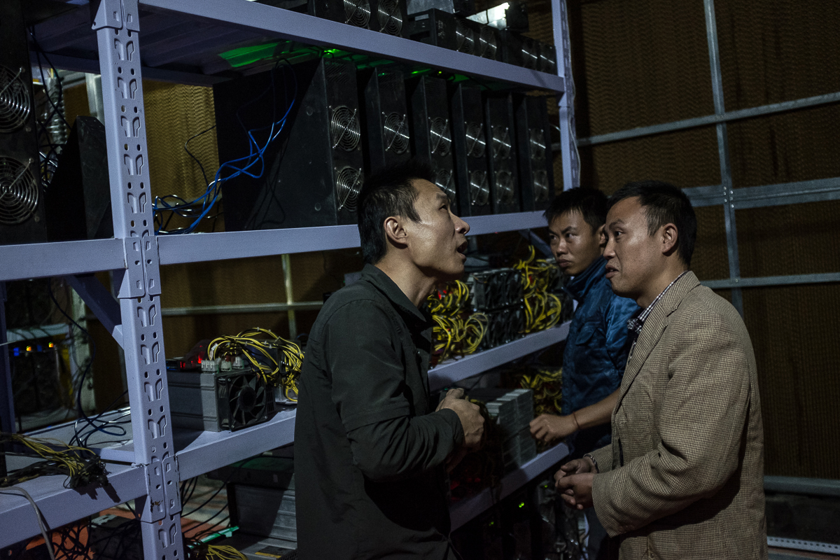 Bitcoin miner Liu, left, meets with clients. He moved from Henan province to Sichuan province in 2015 for cheaper electricity. Now, he manages more than 7,000 mining machines. Meanwhile, his clients can monitor the machines' operation and bitcoin earnings remotely using apps and mobile phones. [EPA/Liu Xingzhe/CHINAFILE]