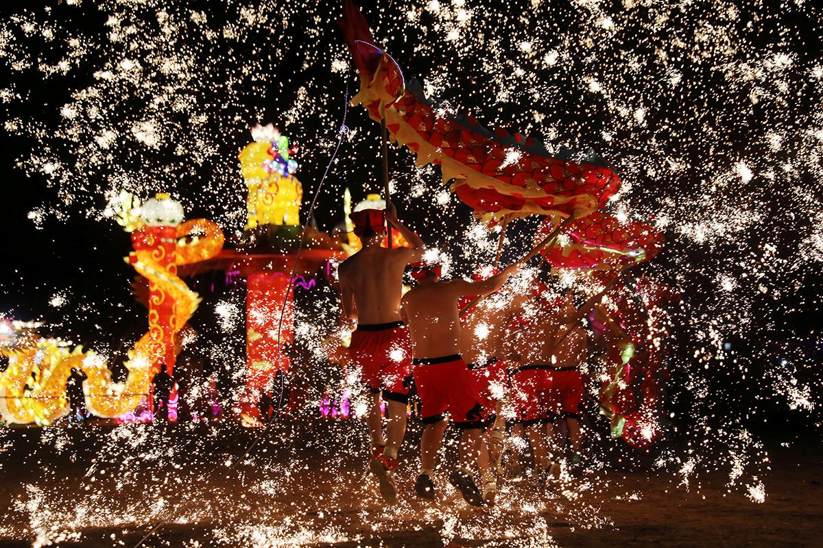Folk artists perform a fire dragon dance under a shower of sparks from molten iron, ahead of the Chinese Lunar New Year, in Shangqiu, Henan province, China. [Reuters]