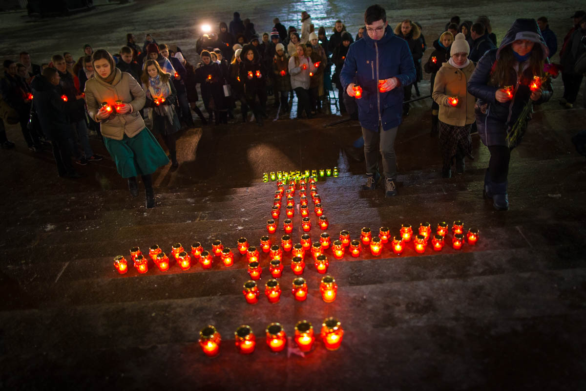 Young people gather at the Cathedral of Christ the Savior in Moscow lighting 71 candles in memory of those killed in the An-148 plane crash. The Russian passenger plane carrying 71 people crashed on Sunday near Moscow, killing everyone aboard. [Alexander Zemlianichenko/AP Photo]