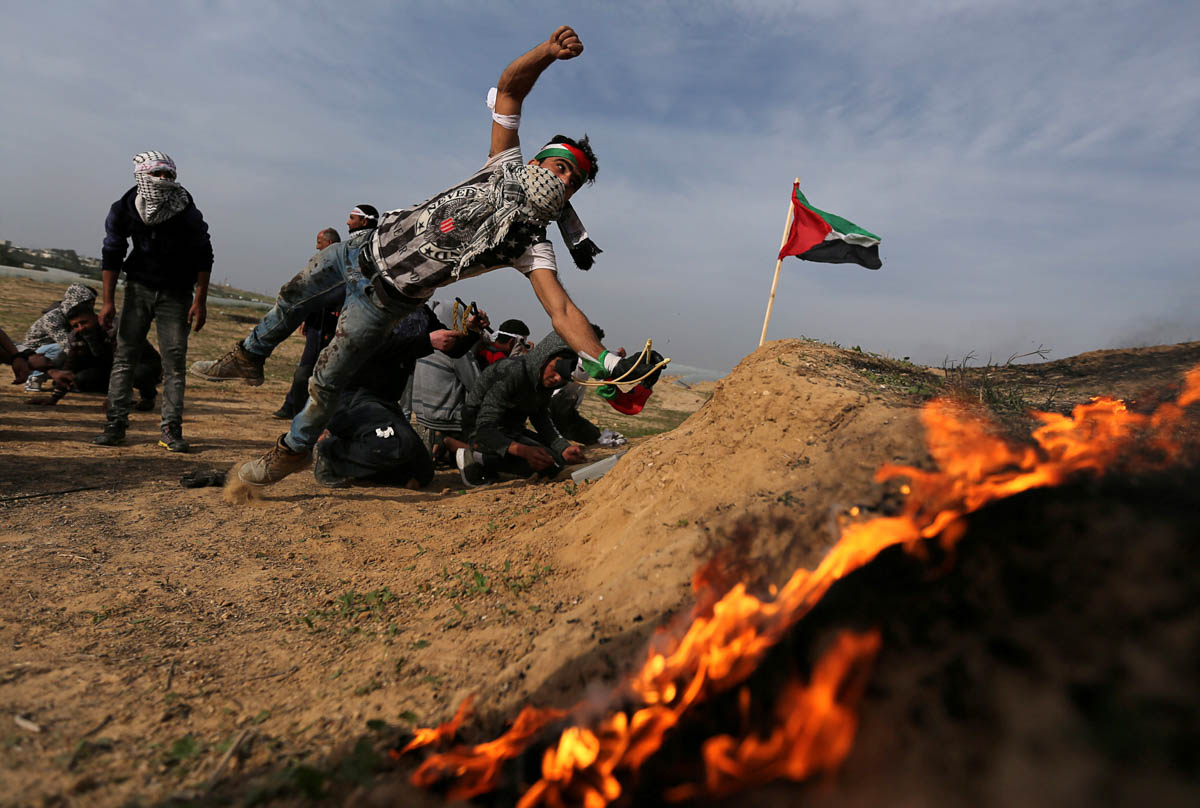 A Palestinian protester reacts during clashes with Israeli forces, near the border with Israel in the southern Gaza Strip. [Ibraheem Abu Mustafa/Reuters]