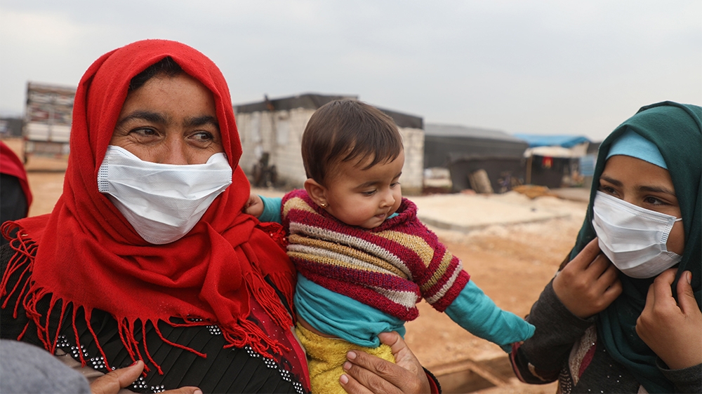 Syrian women wear face masks during an awareness workshop on Coronavirus (COVID-19) held by Doctor Ali Ghazal at a camp for displaced people in Atme town in Syria's northwestern Idlib province, near t
