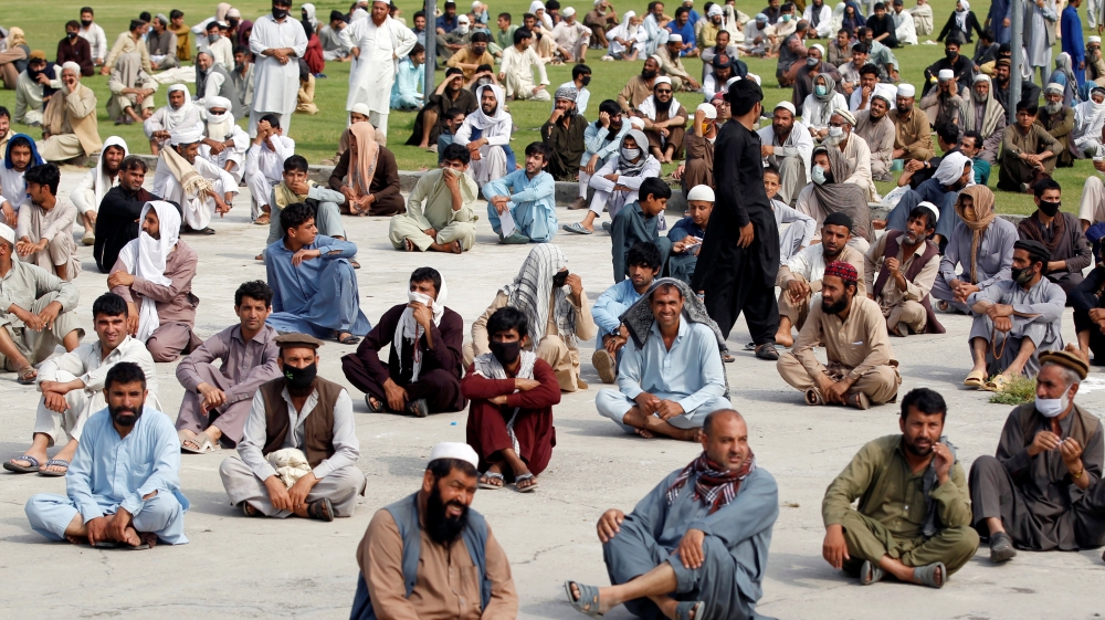 Men wait to receive free food amid coronavirus in Jalalabad, Afghanistan