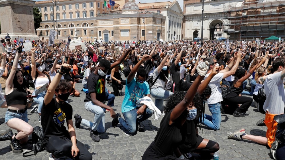 Demonstrators raise their fists as they attend a protest against racial inequality in the aftermath of the death in Minneapolis police custody of George Floyd, at Piazza del Popolo 