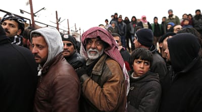  Syrian refugees wait for food near a refugee camp in Bab Al-Salama city, in northern Syria, on February 6 [Sedat Suna/EPA]