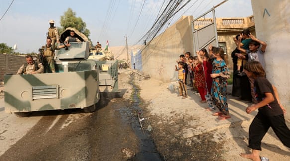 A Kurdish Peshmerga fighter takes a selfie with children after recapturing Fadiliya village [Air Jalal/Reuters]