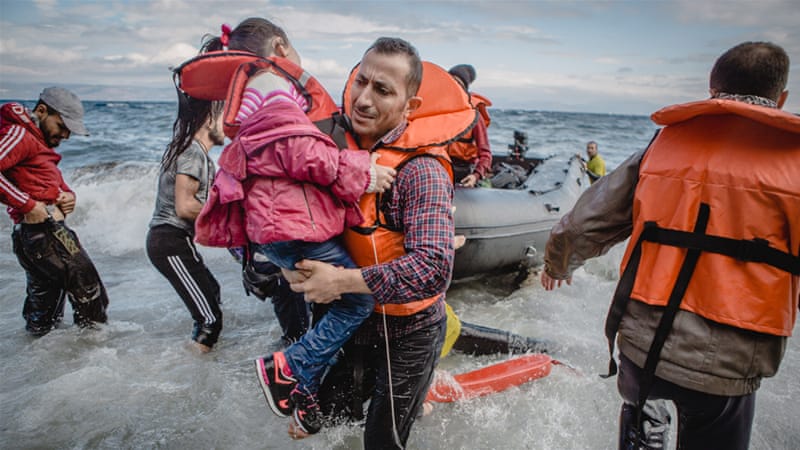 A father carries his daughter off their boat, which was stranded at sea for five hours, and on to the island of Lesbos. [Anna DiCenzo/Al Jazeera]