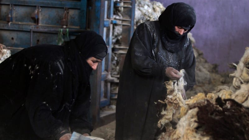 Iraqi women clean piles of animal wool in a tanning factory in the area of Nahrawan, southeast of Baghdad [AFP]