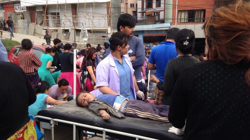 An injured child receives treatment outside Medicare Hospital in Kathmandu (AP)