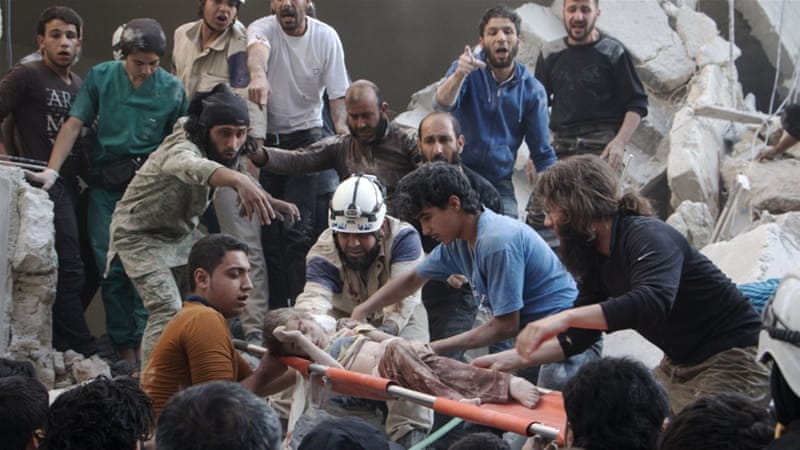 Syrian rescue workers and citizens carry a child on a stretcher after a reported barrel bomb attack in Aleppo [AFP]