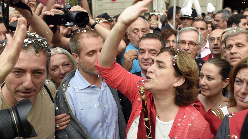 Ada Colau waves to the people as she crosses Sant Jaume square to meet Catalonia's regional president [AFP]