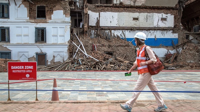 A delegate walks in front of a damaged palace ahead of the International Donors' Conference [Getty]