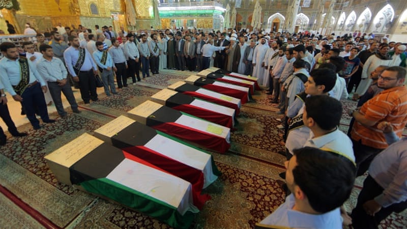 People pray in front of coffins draped with Kuwaiti flags belonging to victims of the Shia mosque bombing in Kuwait [AP]