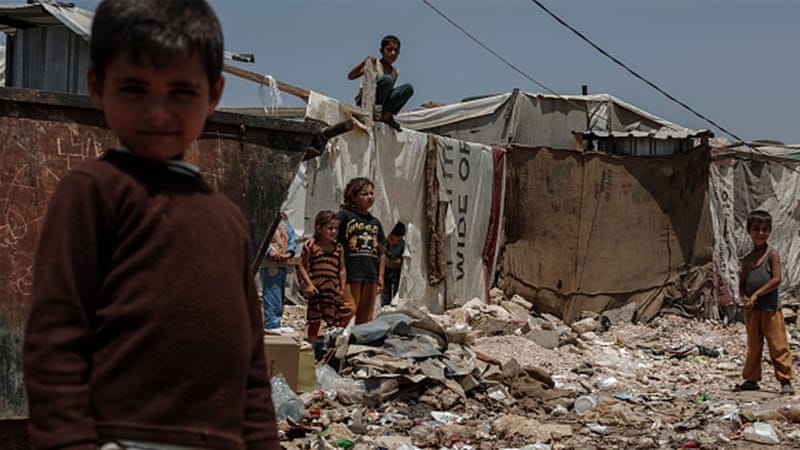 Children play amid rubbish at an informal Syrian refugee settlement near Zahle, Lebanon [Getty]