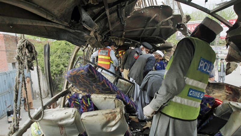 Pakistani security staff examine the bus following a blast in Peshawar on Wednesday [Mohammad Sajjad/AP]