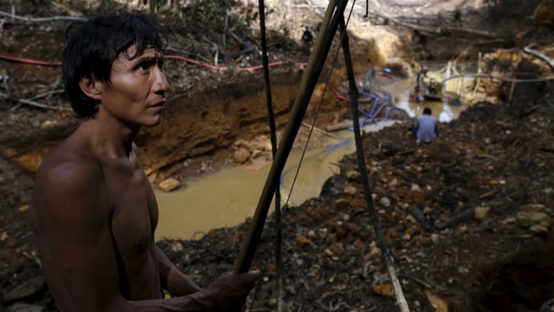 A Yanomami indian stands near an illegal gold mine during Brazil's environmental agency operation against illegal gold mining on indigenous land. [Reuters]