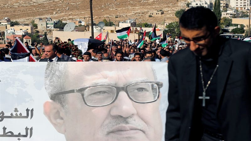 Activists hold a picture of Jordanian writer Nahed Hattar on Wednesday at his funeral [Muhammad Hamed/Reuters]