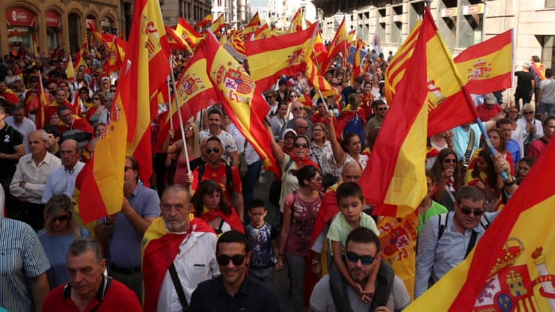 La gente agita banderas españolas y catalanas mientras asisten a una manifestación pro-sindical en Barcelona, ​​España, 8 de octubre de 2017 [Albert Gea / Reuters]