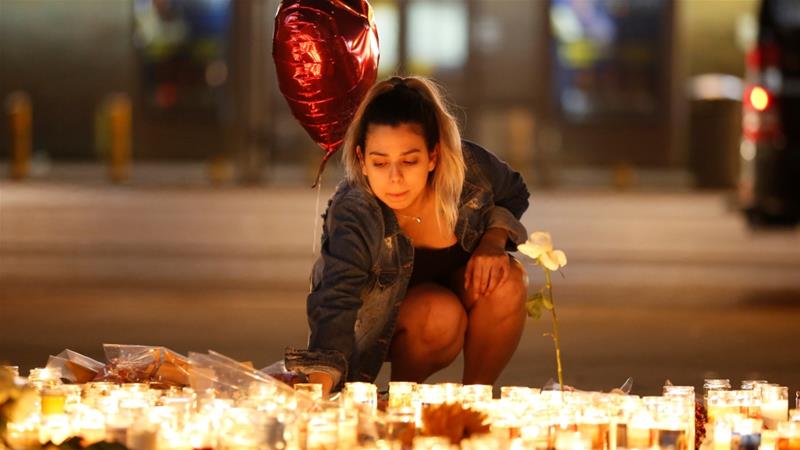 A woman lights candles at a vigil on the Las Vegas strip following the mass shooting [Chris Wattie/Reuters]