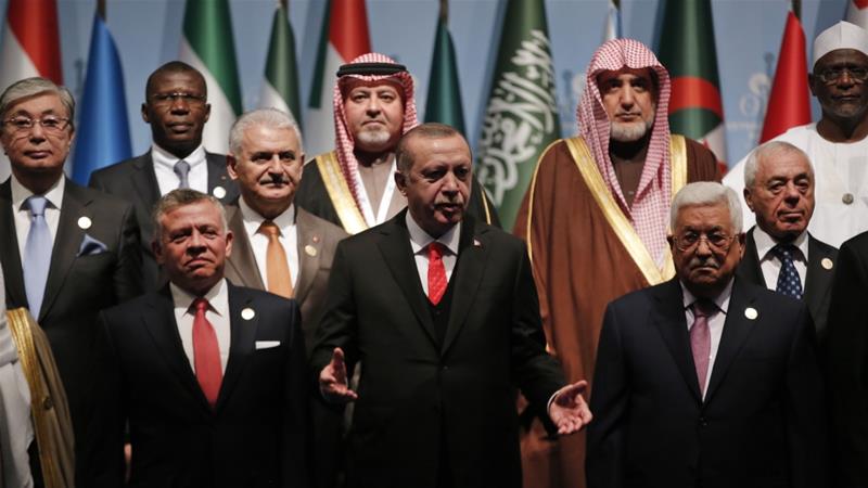 El presidente de Turquía, Recep Tayyip Erdogan, flanqueado por el rey Abdullah II de Jordania y el presidente palestino Mahmoud Abbas gesticula durante una sesión fotográfica previa a la Cumbre Extraordinaria de la OCI en Estambul [AP]