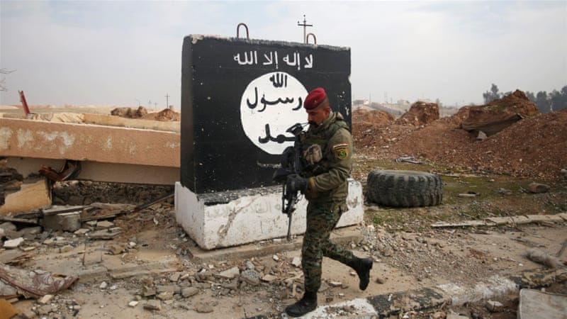 An Iraqi soldier walks next to a wall painted with the black flag commonly used by ISIL, near Arabi neighbourhood, north of Mosul, Iraq, January 21 [Khalid al Mousily/Reuters]