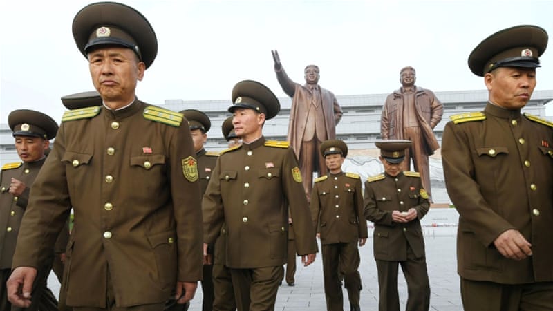 North Korean soldiers walk in front of bronze statues of North Korea's late founder Kim Il-sung and late leader Kim Jong-il at Mansudae in Pyongyang [Reuters]