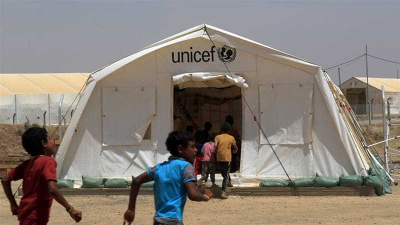 Displaced Iraqi boys enter a tent school set by United Nations Children's Fund (UNICEF) at Hammam al-Alil camp south of Mosul [Ari Jalal/Reuters]