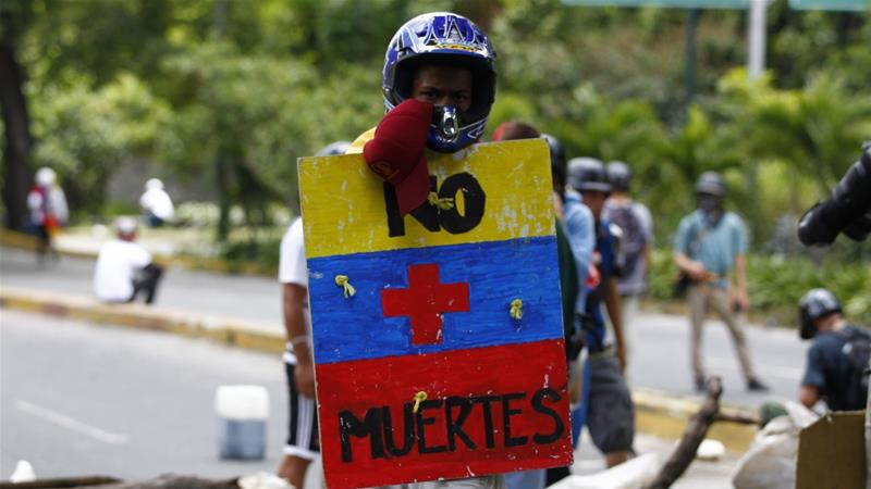 Un partidario de la oposición sostiene un escudo que dice "No más muertes" cuando los enfrentamientos estallan en Caracas el 30 de julio [Reuters / Christian Veron]