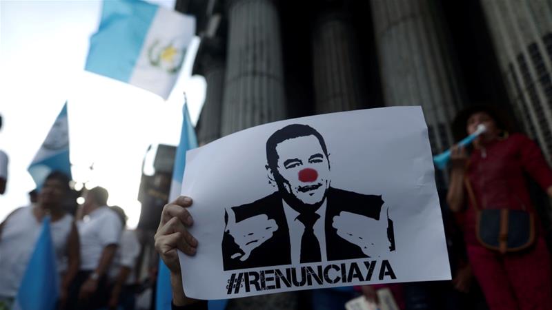 Un manifestante tiene un cartel que pide la dimisión del presidente guatemalteco Jimmy Morales en la ciudad de Guatemala el 27 de agosto [Reuters / Fabricio Alonzo]