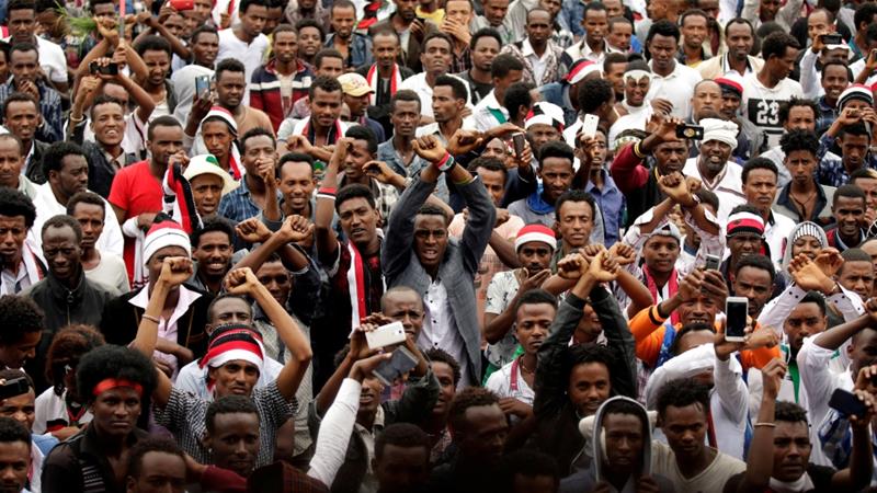 Demonstrators chant slogans while flashing the Oromo protest gesture, in Bishoftu town, Ethiopia [Tiksa Negeri/Reuters]