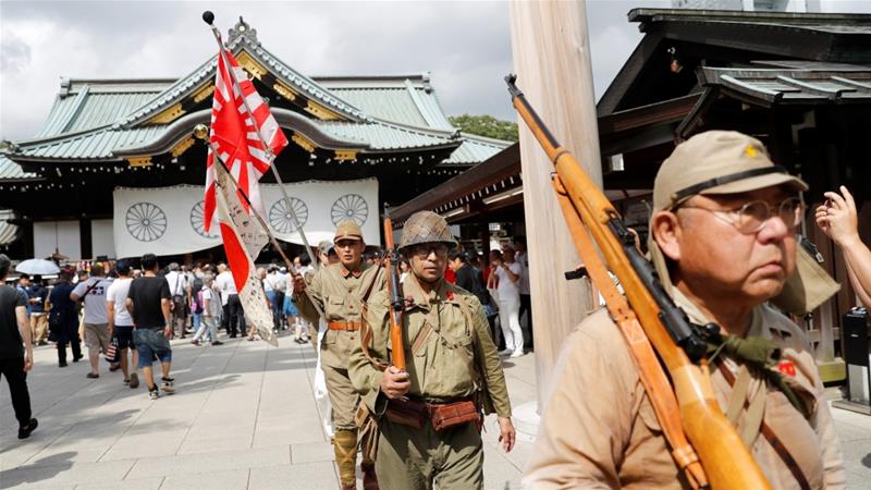 Men wearing Japanese imperial military uniform visit the Yasukuni Shrine in Tokyo on Thursday [Kim Kyung-Hoon/Reuters]