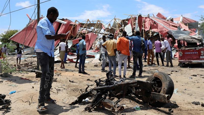 Somalis inspect the damage caused at the scene of an attack on an Italian military convoy in Mogadishu [Feisal Omar/Reuters]
