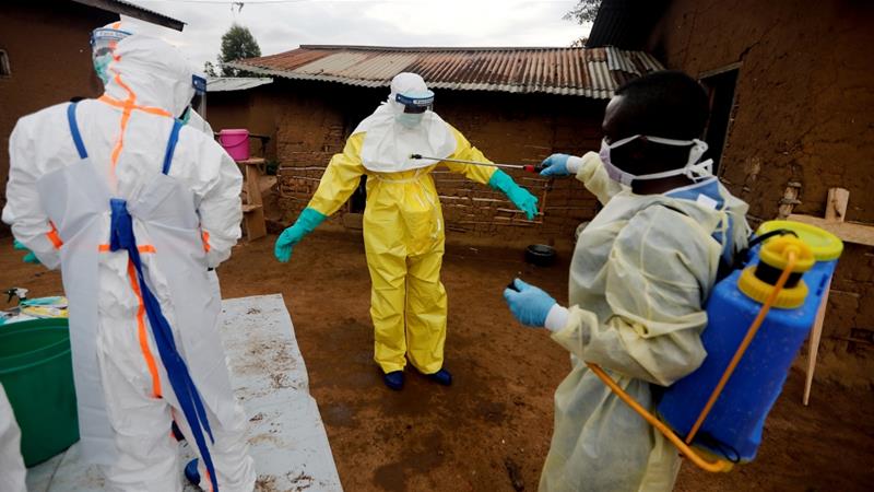 A healthcare worker, who volunteered in the Ebola response, decontaminates his colleague after he entered the house of woman suspected of dying of Ebola in DRC [File: Zohra Bensemra/Reuters]