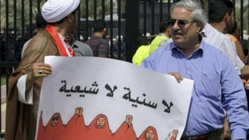 In Bahrain (circa March 2011), both Shia and Sunni  opposition leaders come together, holding a sign reading "No Sunni, No Shia: One unified nation." [AP]
