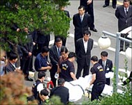 Hyundai Asan Co. Chairman Chung Mong-hun's body is carried away by South Korean police