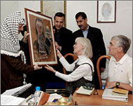 Craig (R) and Cynthia Corrie (2nd R) received a portrait of their daughter  from Yasir Arafat 