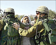 Israeli soldiers push a Palestinian