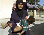 A nurse carries a wounded boy injured in Khan Bani Saad attack
