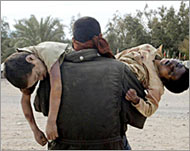 Iranian man carries his two sons to the cemetery 
