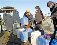 Iraqis queue to fill their plasticcans with kerosene