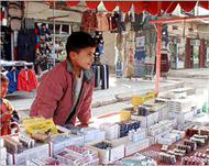 Qatham helps his father sell medicines at the market