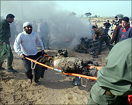 A body is carried away from the car hit by an Israeli missile