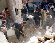Men dig through the ruins of a house destroyed in Falluja 